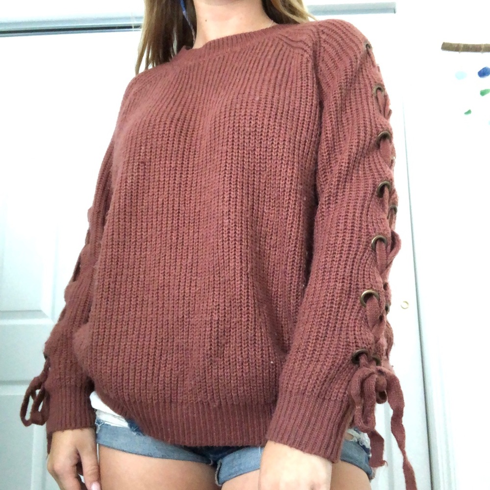 Burnt orange sweater with laces on the sleeves